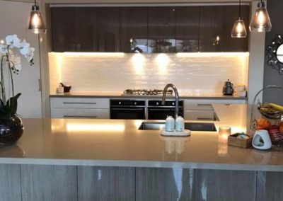 contemporary kitchen completed, from standing in front of the L shaped Bench top looking into the kitchen with glossy finish on all the cupboards